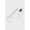 White leather sneakers with a signature logo