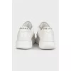 White leather sneakers with a signature logo