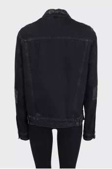 Black denim jacket with a distressed effect
