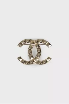 Brooch in the shape of the brand logo