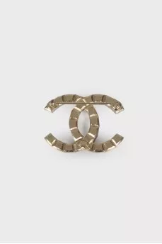 Brooch in the shape of the brand logo