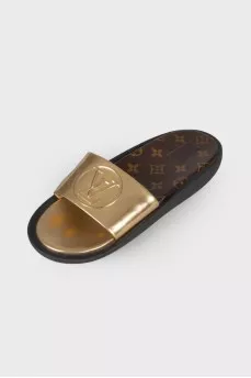 Golden slippers with brand logo