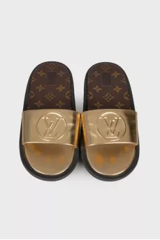 Golden slippers with brand logo