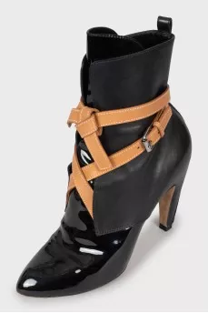 Black leather ankle boots decorated with ties