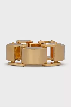 A chunky gold bracelet with a tag