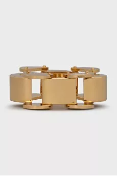 A chunky gold bracelet with a tag