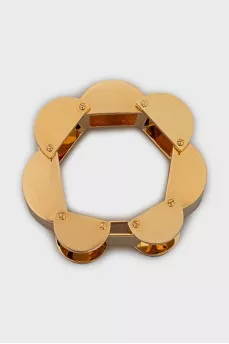 A chunky gold bracelet with a tag