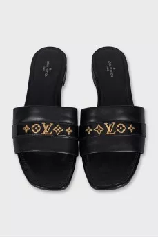 Black leather flip-flops with gold trim