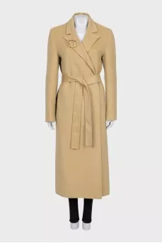 Beige coat with a signature brooch
