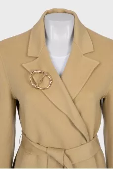 Beige coat with a signature brooch
