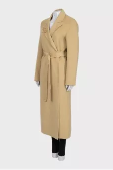 Beige coat with a signature brooch