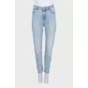Light blue jeans with a tapered fit and a button fly