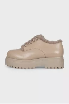 Beige fur-lined boots with a tag