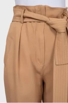 Beige tapered trousers with a belt