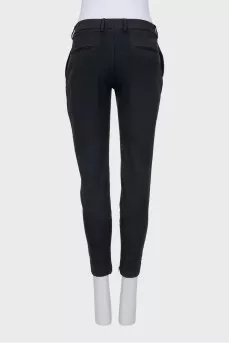 Tapered black trousers with a zip at the bottom