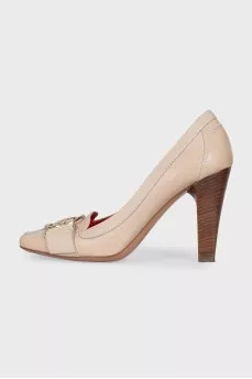 Beige leather shoes with a gold logo