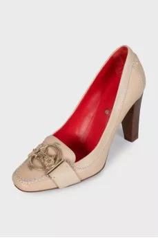 Beige leather shoes with a gold logo