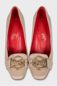 Beige leather shoes with a gold logo