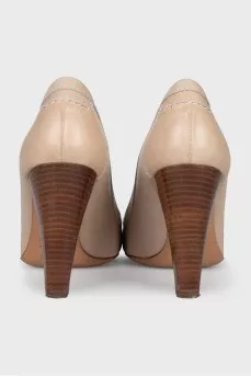 Beige leather shoes with a gold logo
