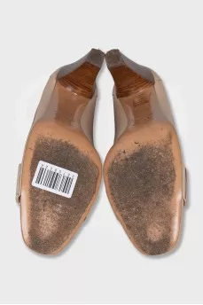 Beige leather shoes with a gold logo
