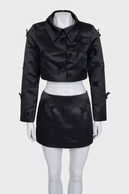 A suit consisting of a cropped jacket and a miniskirt