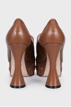 Brown shoes with a shaped heel and a tag