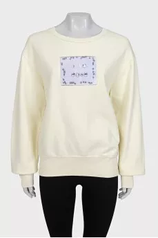 Yellow sweatshirt with a patch on the front