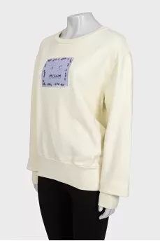 Yellow sweatshirt with a patch on the front