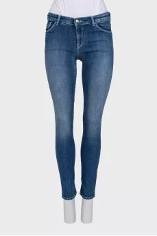 Skinny blue jeans with a logo on the pocket