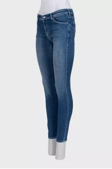 Skinny blue jeans with a logo on the pocket