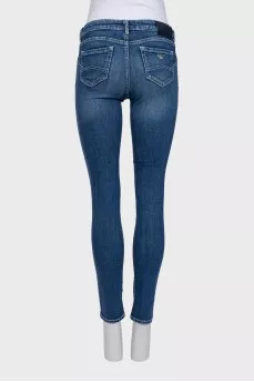 Skinny blue jeans with a logo on the pocket