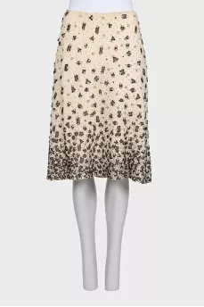 The beige skirt is decorated with sequins