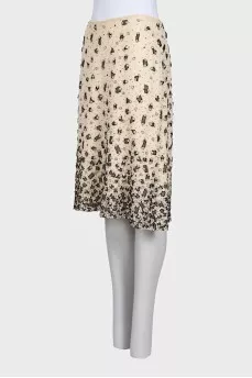 The beige skirt is decorated with sequins