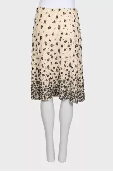 The beige skirt is decorated with sequins