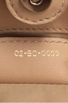 Beige fabric bag with a branded pendant