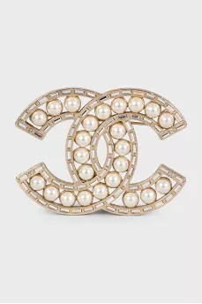 Golden decorated logo brooch