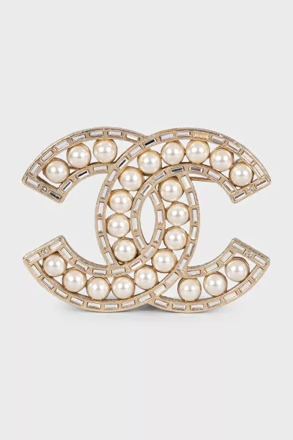 Golden decorated logo brooch