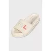 White leather flip-flops with a multi-colored logo