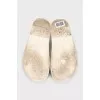 White leather flip-flops with a multi-colored logo