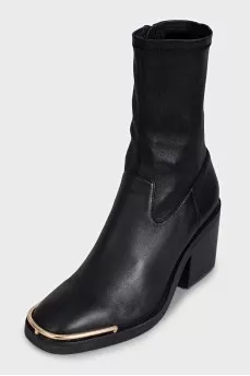 Black ankle boots with gold embellishments on the front