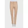 Beige tapered trousers with creases at the front