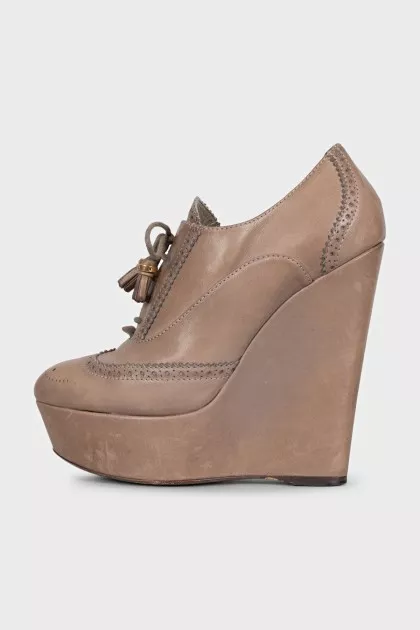 Leather ankle boots with a wedge heel and perforations
