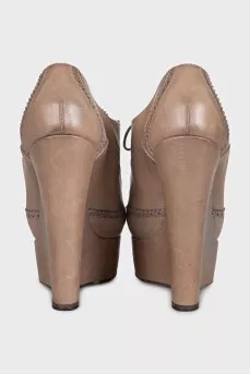 Leather ankle boots with a wedge heel and perforations