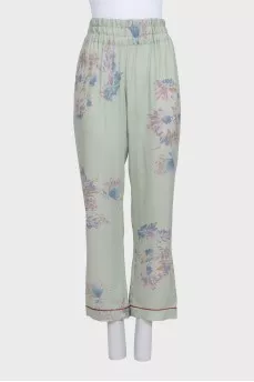 Green silk trousers with a floral print