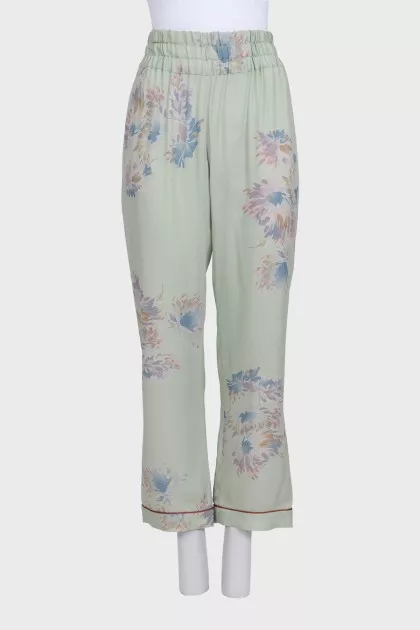 Green silk trousers with a floral print