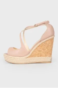 Leather sandals on a high straw wedge, with a tag