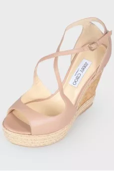 Leather sandals on a high straw wedge, with a tag