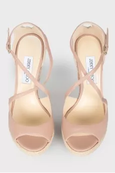 Leather sandals on a high straw wedge, with a tag