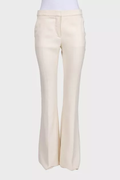 White high-waist flared trousers with creases