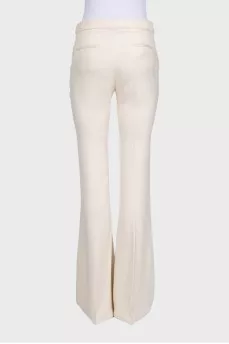 White high-waist flared trousers with creases